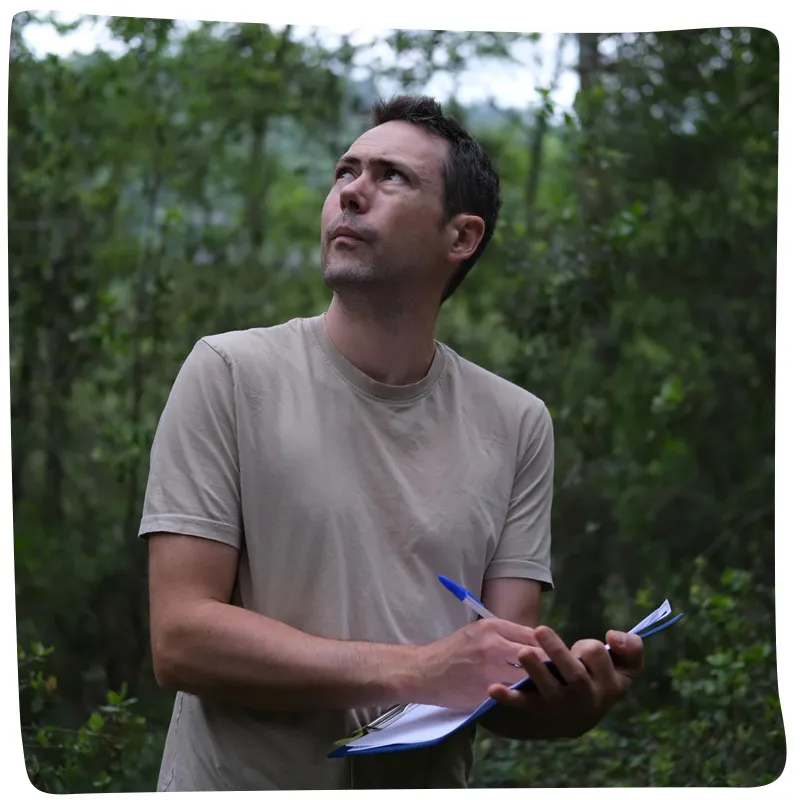 Homme prenant des notes dans une forêt