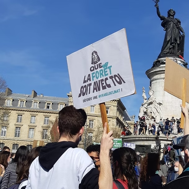 Bénévole qui tient une carte où il est écrit : que la forêt soit avec toi